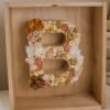 Letra de flores en caja de madera